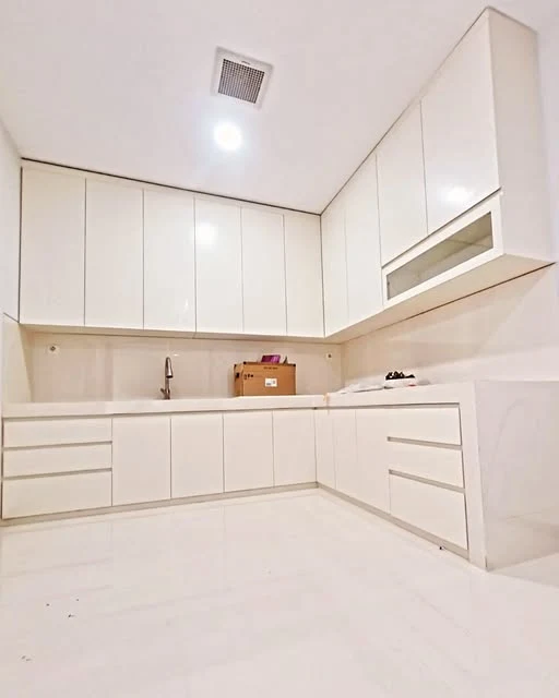 Portofolio kitchen set putih berbentuk L dengan kabinet atas, laci, dan area wastafel