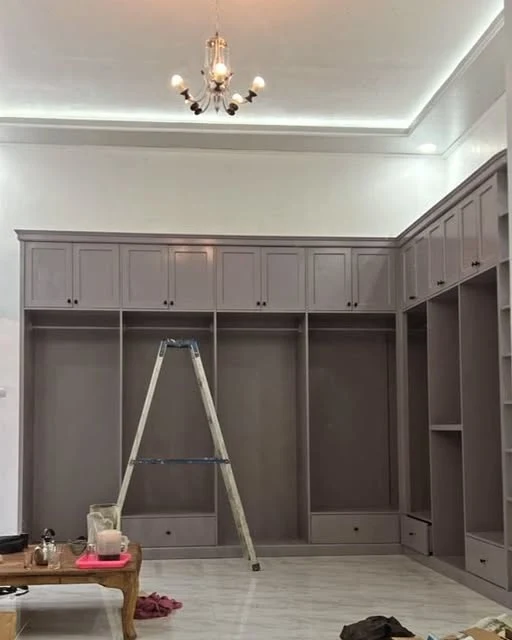 Proses pemasangan wardrobe dengan kabinet atas, kompartemen terbuka, dan laci bawah